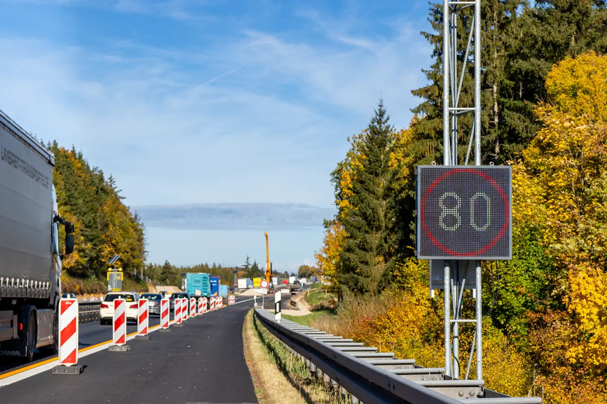 LED-Anzeige mit Tempo 80 am Gittermast neben der Baustellenverkehrsführung der A3 an der Talbrücke Krondorf