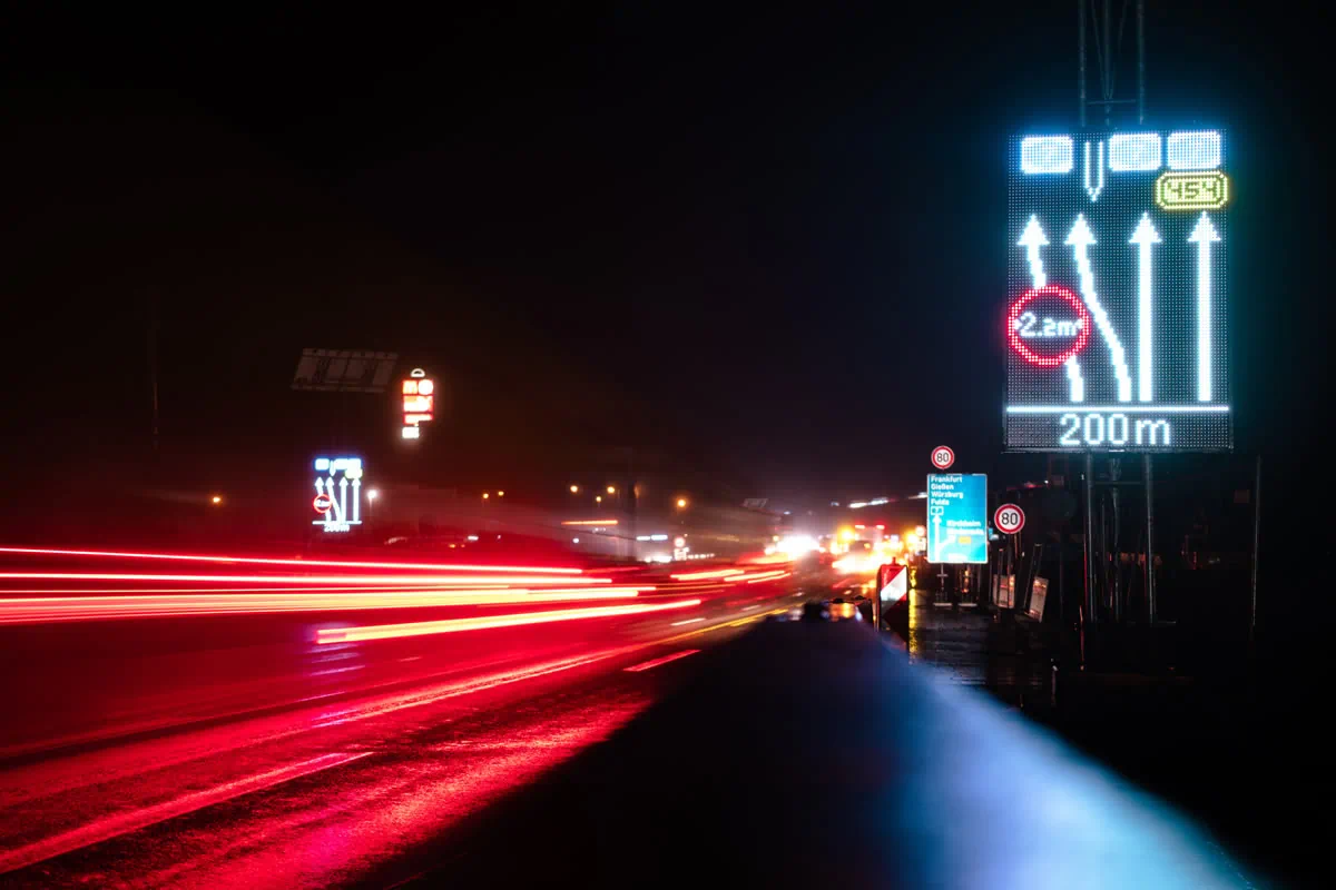 Night shot of an LED display with lane arrows, a 2.2 m width restriction and a 200 m notice at the Kirchheimer Dreieck interchange (A7)