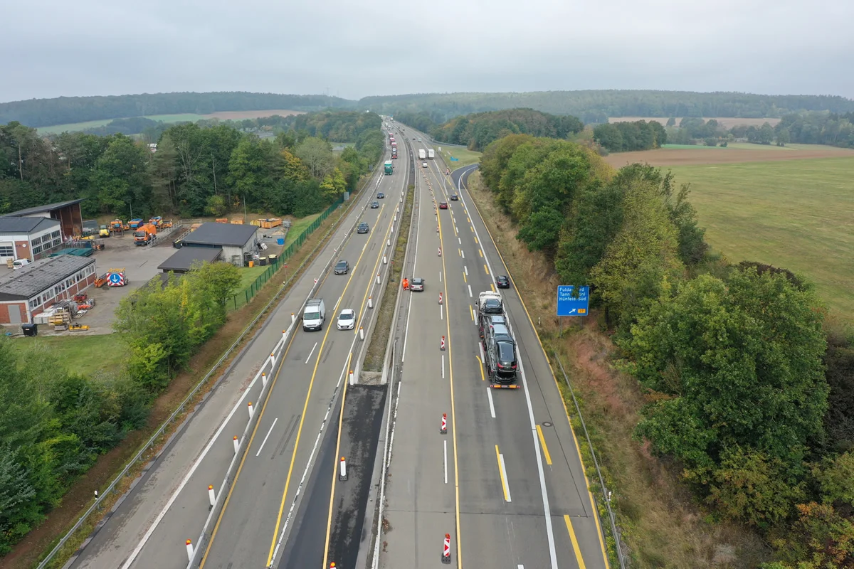 Luftaufnahme der A7 bei Götzenhof mit Baustelle im Mittelstreifen und Gewerbegebiet am Fahrbahnrand