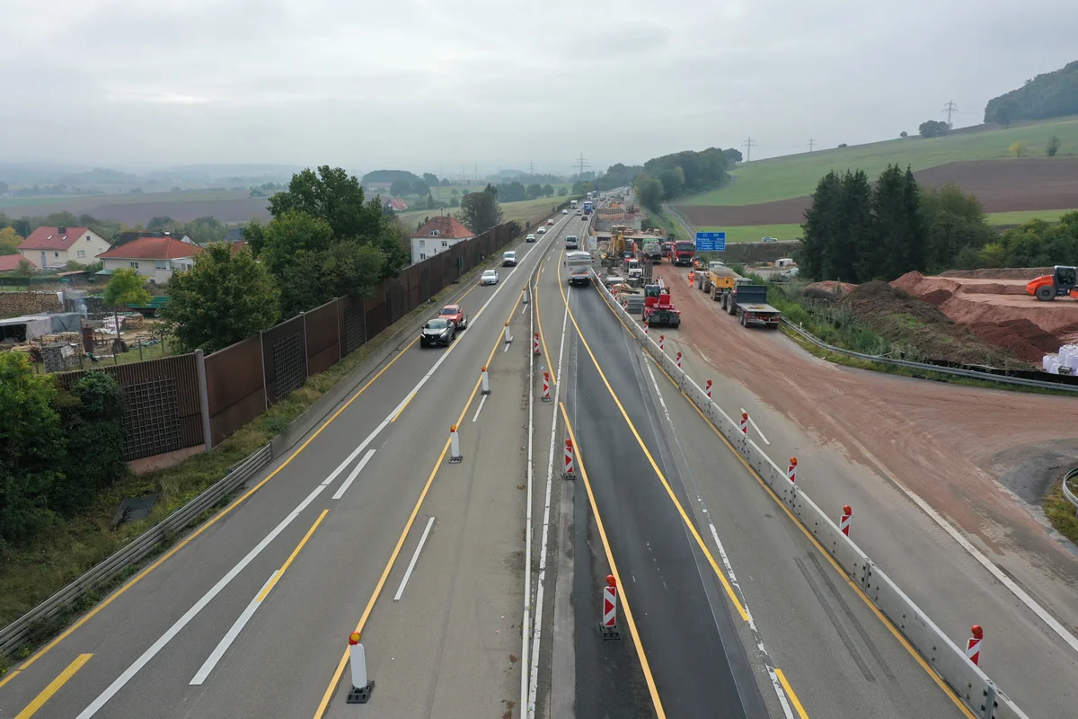 Luftaufnahme der Baustelle an der A7 bei Götzenhof mit Verkehrsführung, Baufahrzeugen und Lärmschutzwand